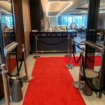 Red carpet runner leading through glass entrance of event building
