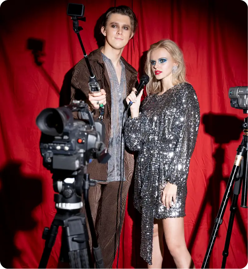 Couple posing together in formal outfit near red curtain backdrop