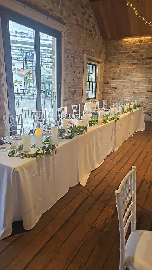 Decorated wedding reception head table with floral garland arrangement