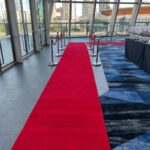 Long red carpet runner layout inside modern corporate event hall