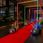 Outdoor event entrance path featuring illuminated colorful light arches