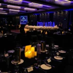 Darkened event reception space with illuminated stage display backdrop