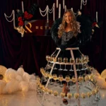Woman wearing black feather outfit and glowing champagne glass skirt