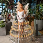 Woman in white suit with feather wings and champagne skirt