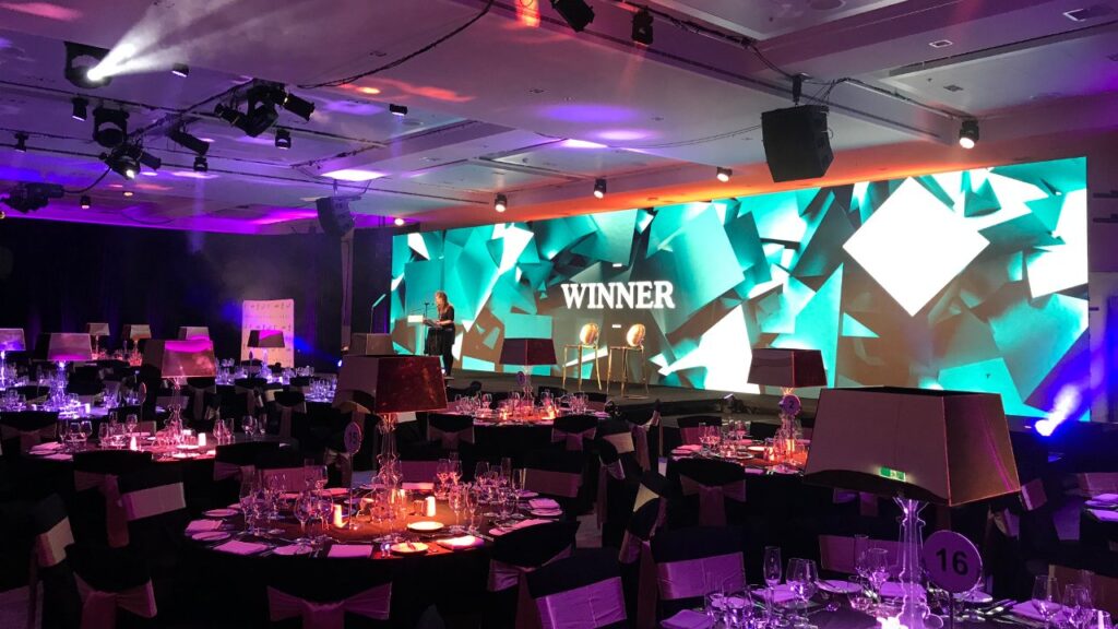 Large stage setup with illuminated digital screen at event