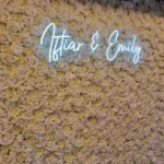Custom neon sign reading "Arthur & Emily" mounted outdoors