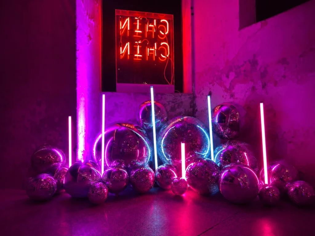 Vertical neon tube lights illuminating dark stage venue with purple