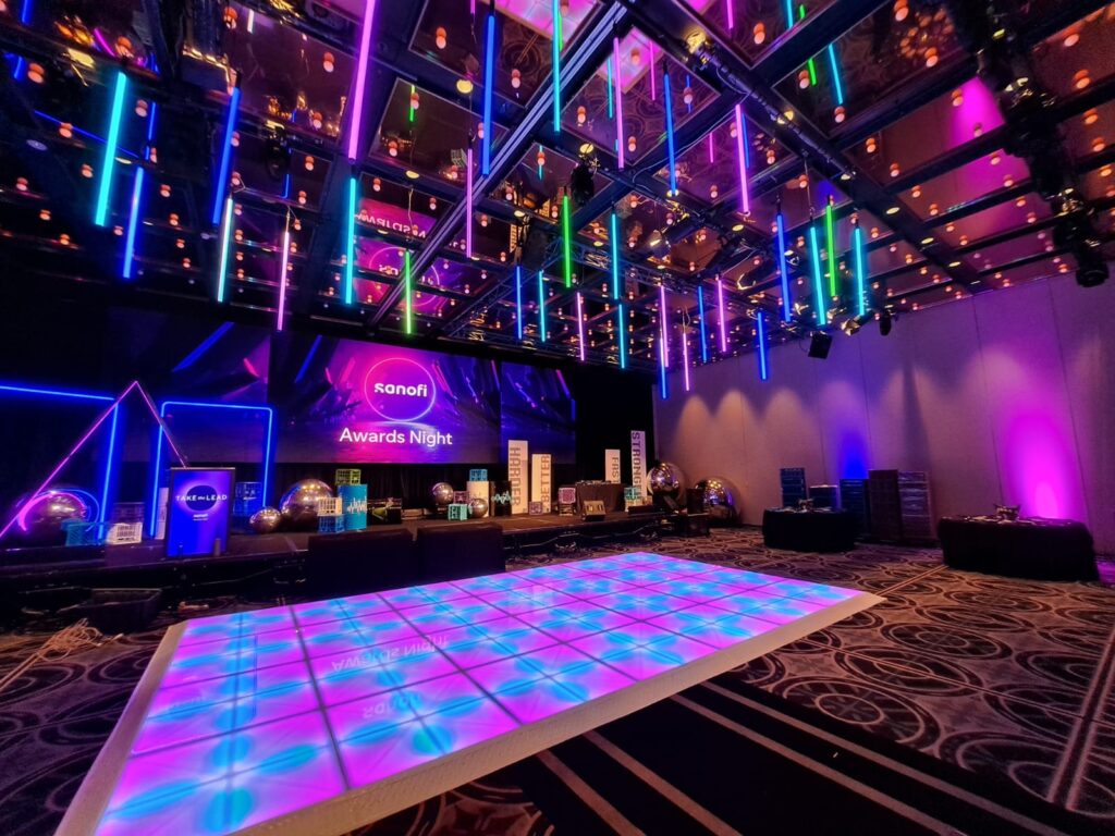 Event space with lit dance floor and hanging LED tubes