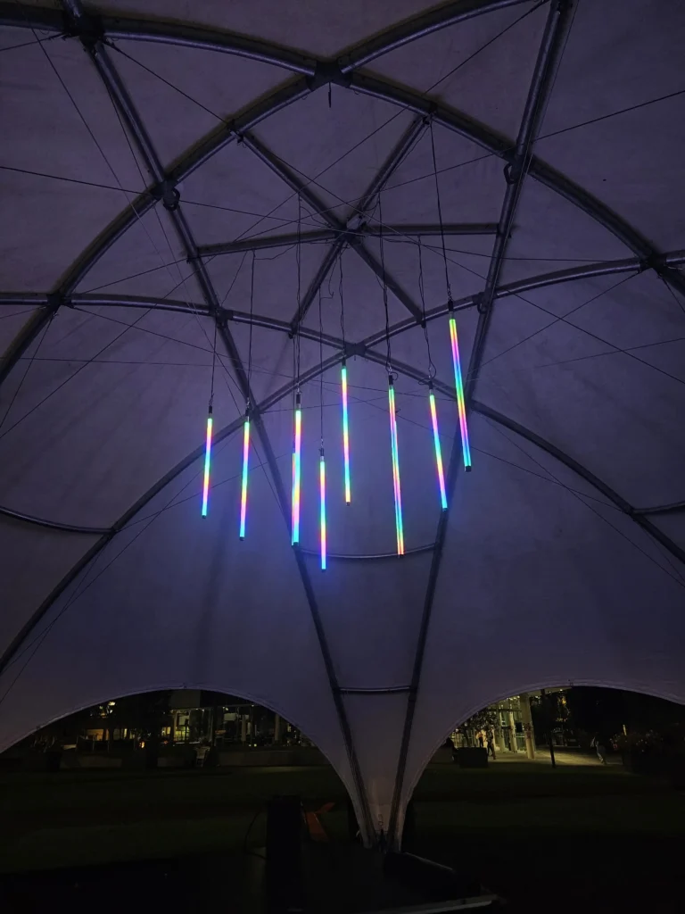 Cluster of vertical blue LED tubes suspended from high ceiling