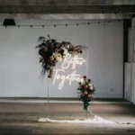 Minimalist event backdrop wall with small central floral setup