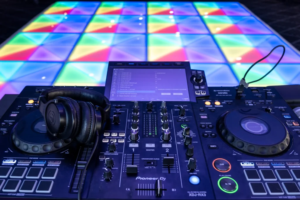 DJ mixer console setup with glowing LED dance floor