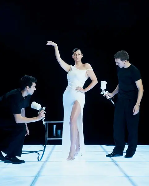 Model in white dress posing for photoshoot crew