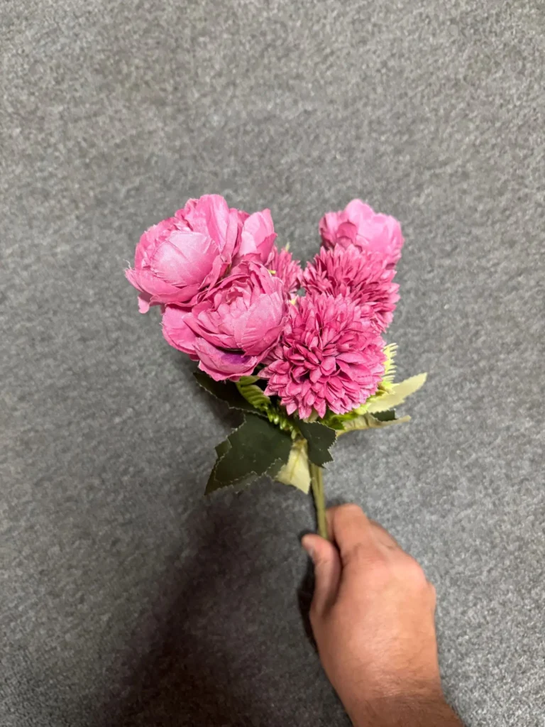 A stem of pink flowers against gray.