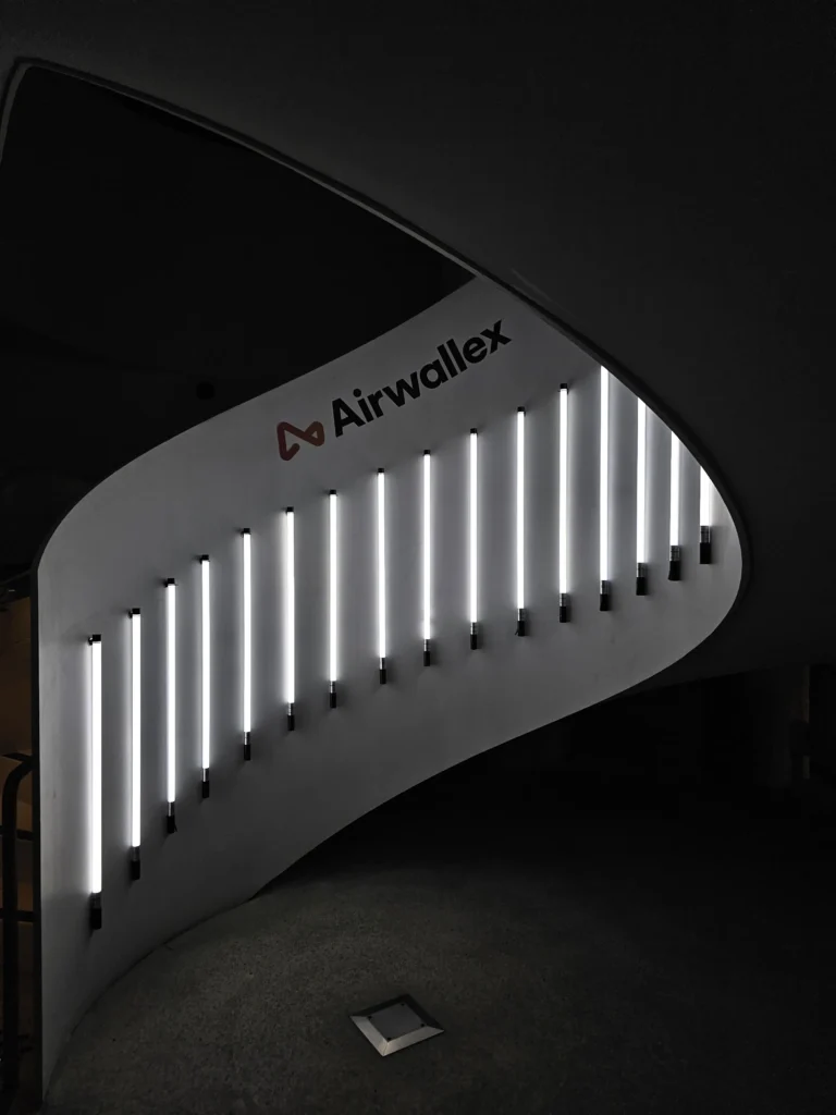 Curved wooden architectural wall featuring integrated warm vertical LED lighting