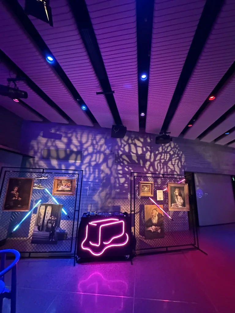 Stage area lit with purple ambient spotlights and background graphics