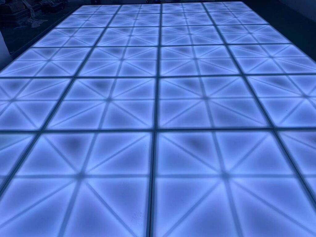 Blue illuminated square grid dance floor at event setup