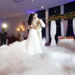 Bride and groom dancing surrounded by thick white dry ice fog