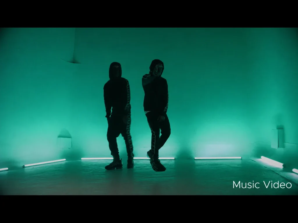 Silhouettes of two people standing against glowing green lit wall