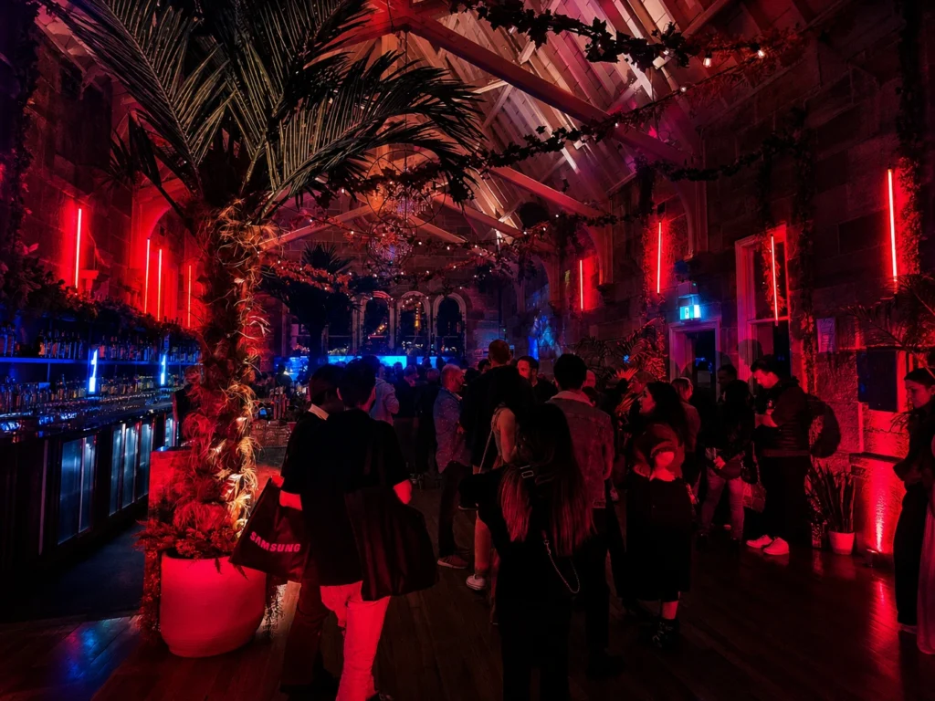 Outdoor night venue styled with red ambient lighting and trees