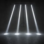 Four white pinspot light beams pointing to the ground