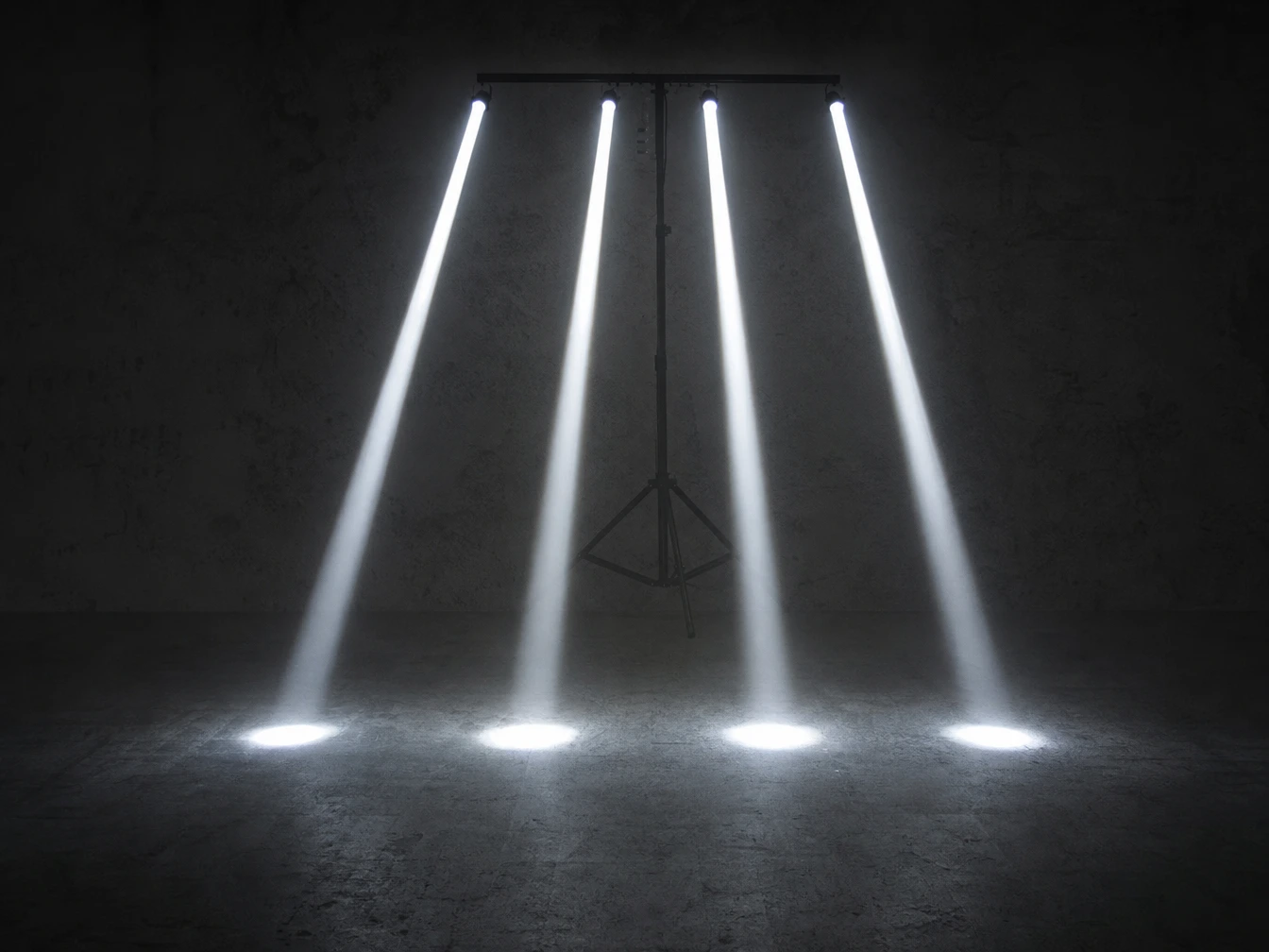 Four white pinspot light beams pointing to the ground