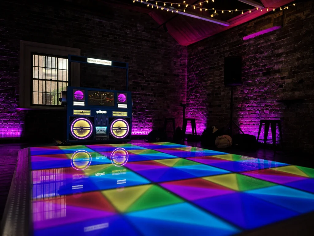 DJ equipment on stage in purple lit venue room