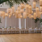 Numerous woven wicker pendant lights hanging over reception tables