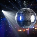 Shiny mirror disco ball illuminated by a bright spotlight