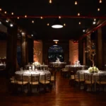 Warm overhead string lights illuminating an elegant event hall.