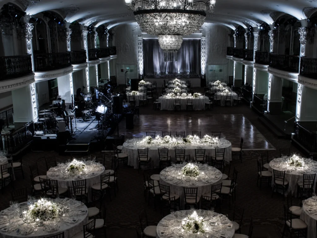Overhead view of illuminated event hall with pinspot tables