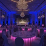 Elegantly lit ballroom tables with pink under-table lighting setup