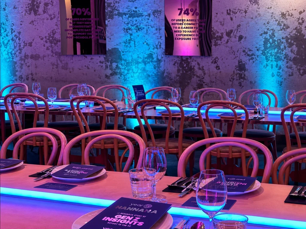 Banquet dining tables illuminated under vibrant blue ambient event lights
