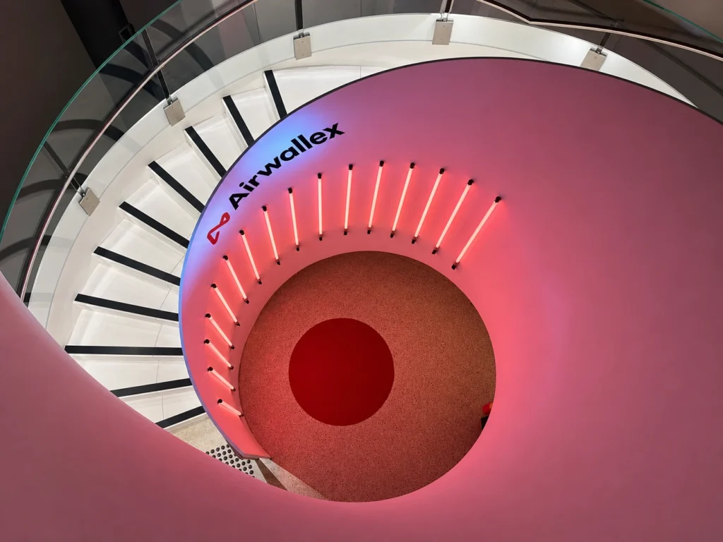 Architectural spiral staircase view illuminated with pink ambient interior lighting