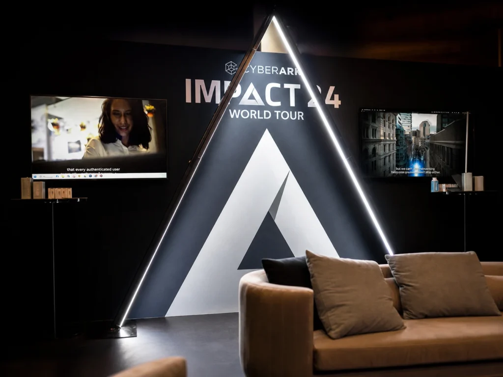 Triangular illuminated structure displaying IMPACT text.