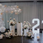 White birthday party decor with illuminated marquee number 21