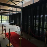 Black pipe and drape curtain backdrop installed inside venue space