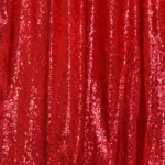 Vibrant red sequin backdrop curtain hanging on frame structure.