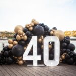 White light-up number 40 with black and gold balloons