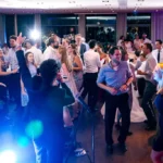 People dancing and celebrating at a wedding reception party indoors.