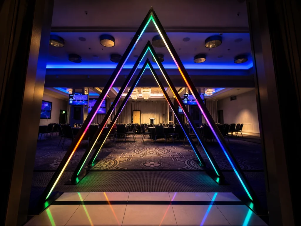 Triangular neon light tunnel creating illuminated walkthrough pathway