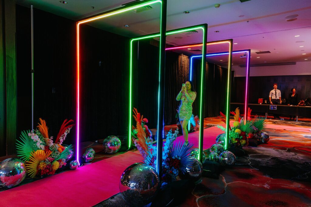 Person walking through illuminated rectangular LED light tunnel