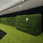 Long row of hedge walls lining an indoor event corridor