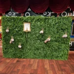 Green artificial hedge wall decorated with small white lights