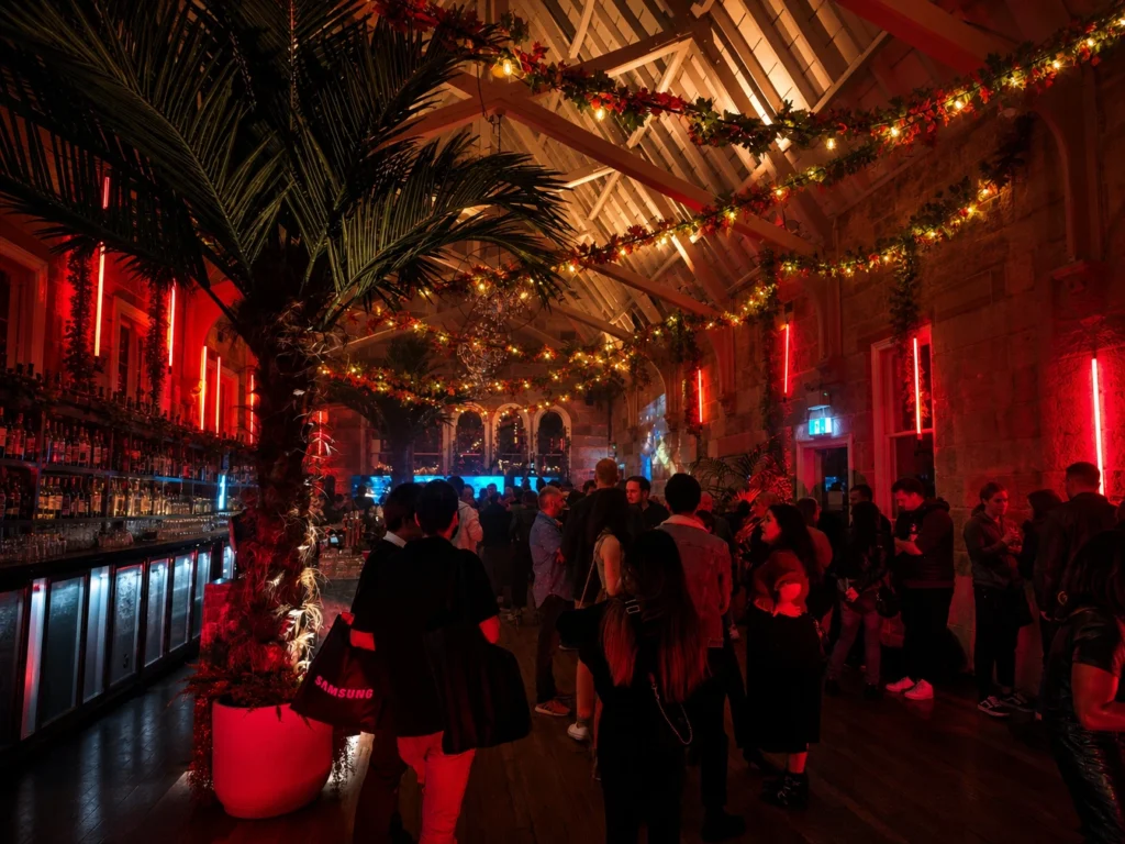 Rustic indoor reception venue styled with overhead festoon light strands