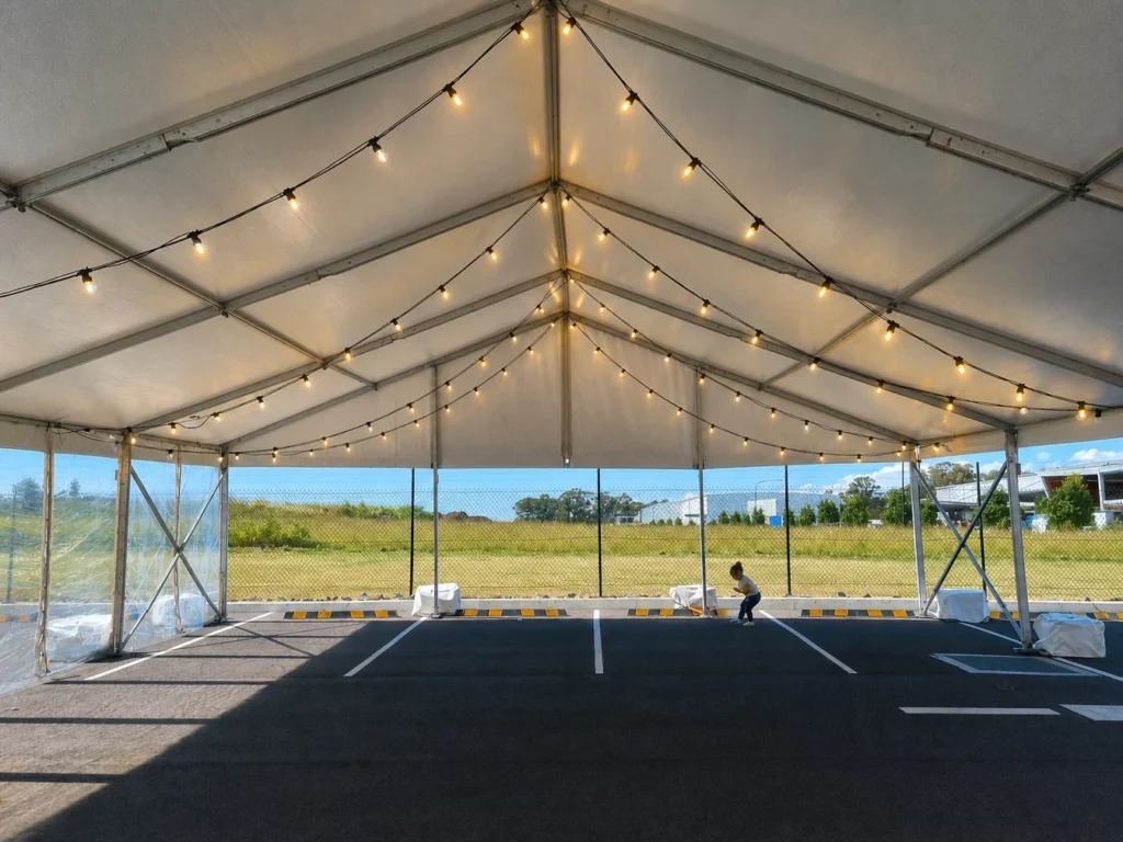 White marquee event tent interior styled with warm ceiling lights