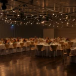 Venue hall space styled with warm festoon lights overhead canopy