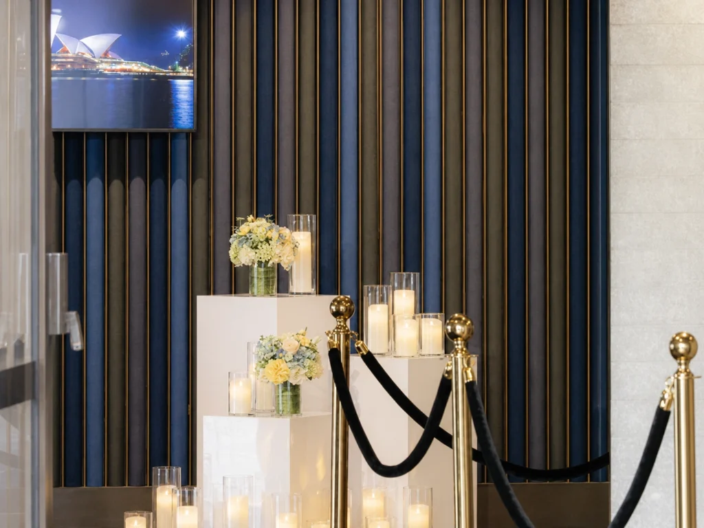 Event podium setup decorated with white floral and candle arrangements.