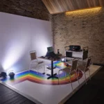 Rainbow-striped dance floor with stage lighting in rustic room