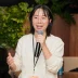 Corporate event speaker presenting beside a vibrant pink and orange floral arrangement